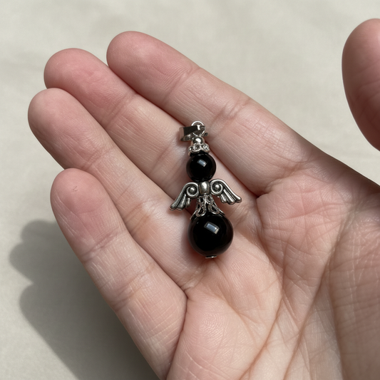 engelhanger van zwarte agaat in de hand