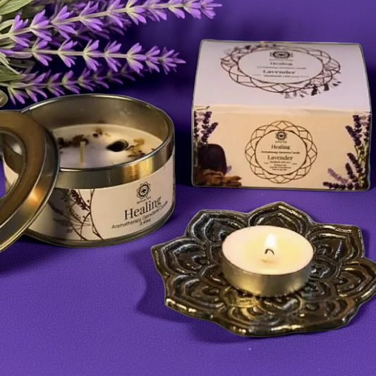 Foto van een lavendel edelsteenkaars in blik met edelsteentjes op de kaars en een brandend theelichtje ernaast