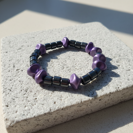 hematiet armband met paarse accenten op een steen in het zonlicht