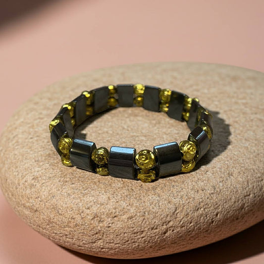 hematiet armband met goudkleurige roosjes op een kei