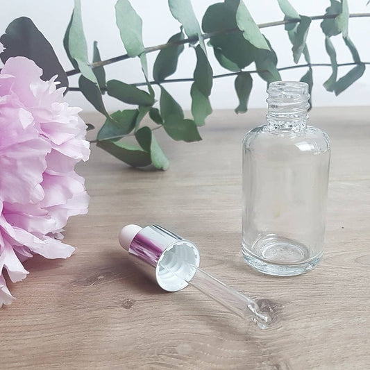 leeg pipet flesje geopend met bloemen erbij