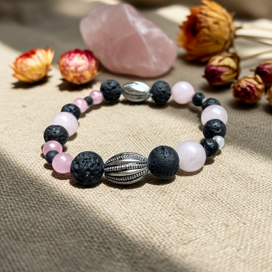 rozenkwarts armband met lavasteen op een linnen doek met gedroogde bloemen en een kristal op de achtergrond