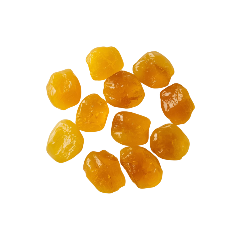 Transparante goudgele stukjes copalhars, glanzende natuurlijke hars in onregelmatige vormen op neutrale achtergrond.