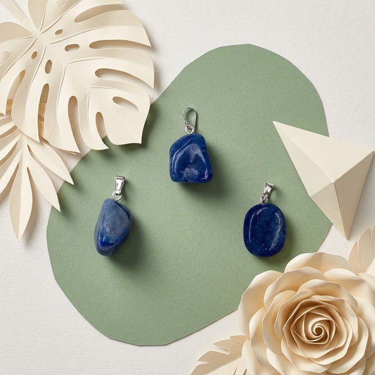 blauwe kwarts hangers op groene ondergrond met beige bloemknutsels
