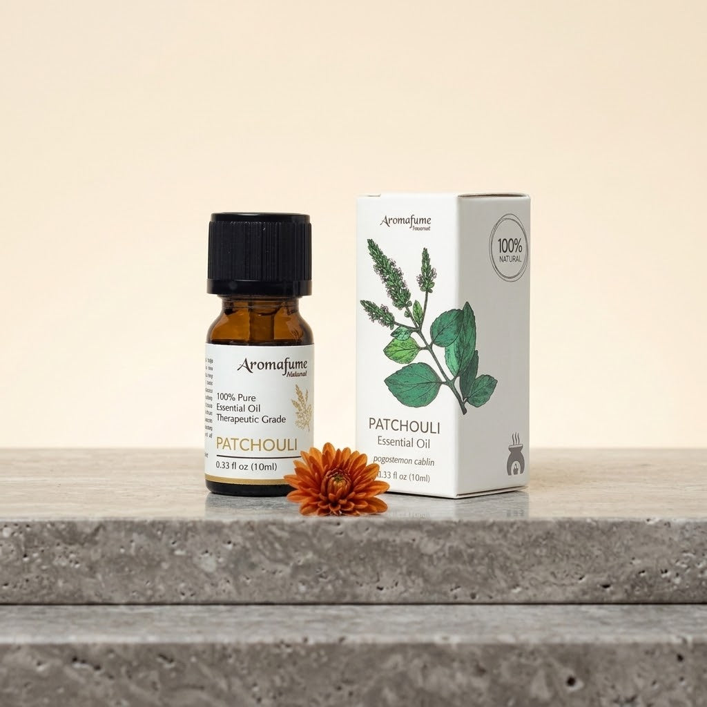 flesje en doosje patchouli etherische olie op een natuursteen met een klein bloemetje erbij