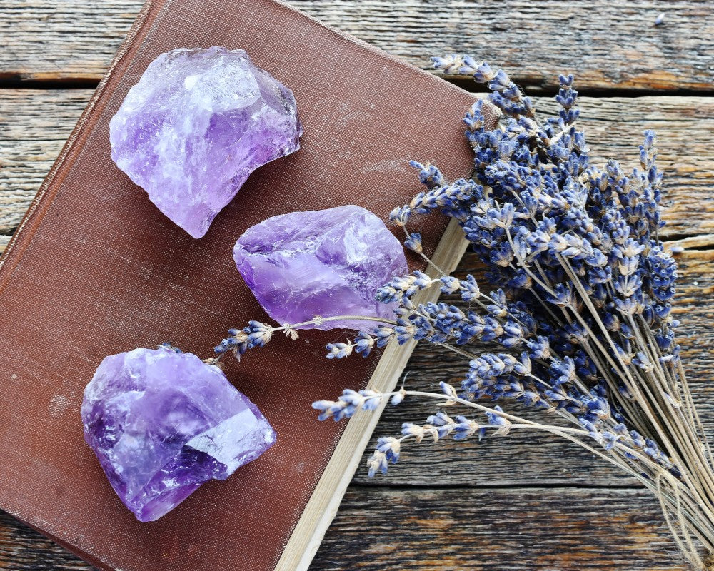 amethist kristallen op een boek met gedroogde lavendel ernaast