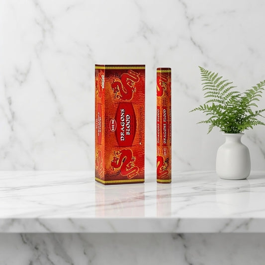 kleine en grote doos wierookstokjes dragons blood op een marmeren tafel met een plantje naast