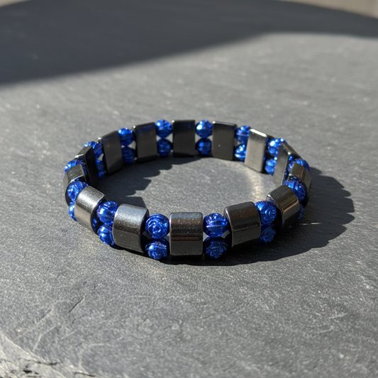 hematiet armband met blauwe roosjes  op een lei in het zonlicht