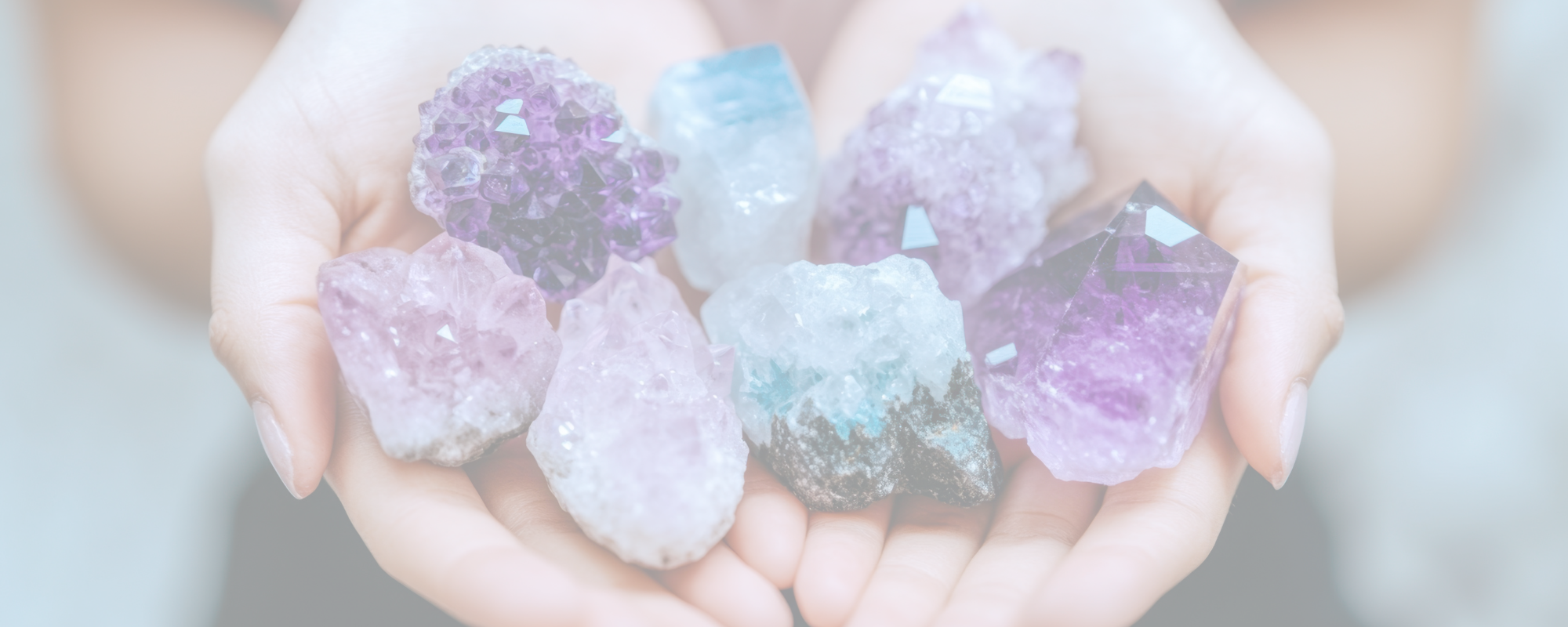 een aantal ruwe stukken kristallen in twee handen gehouden