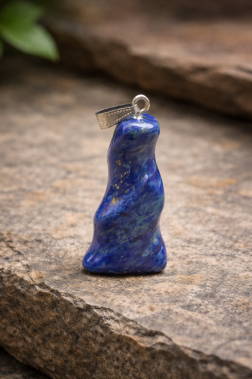 gedraaide lapis lazuli hanger op een steen