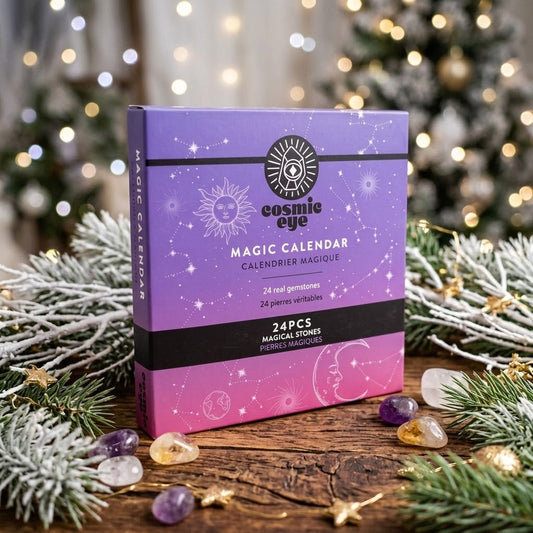kristal adventkalender op een houten tafel met wat besneeuwde takken erachter en wat trommelsteentjes errond