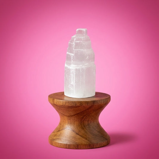 mini monoliet van seleniet op een houten staander met roze achtergrond
