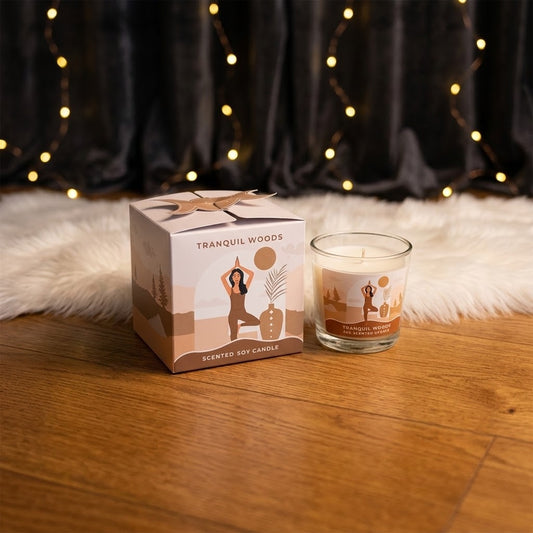 tranquil woods kaars met doosje op een houten vloer met tapijt en lichtjes op de achtergrond