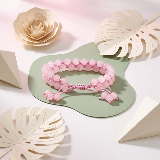 verstelbare rozenkwarts armband op groene ondergrond met beige bloemenknutsels