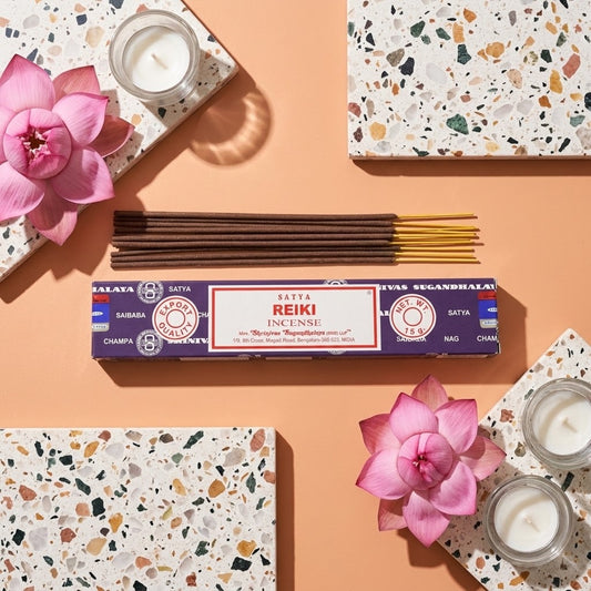 doosje reiki wierook met losse stokjes omringd door bloemen en tegels