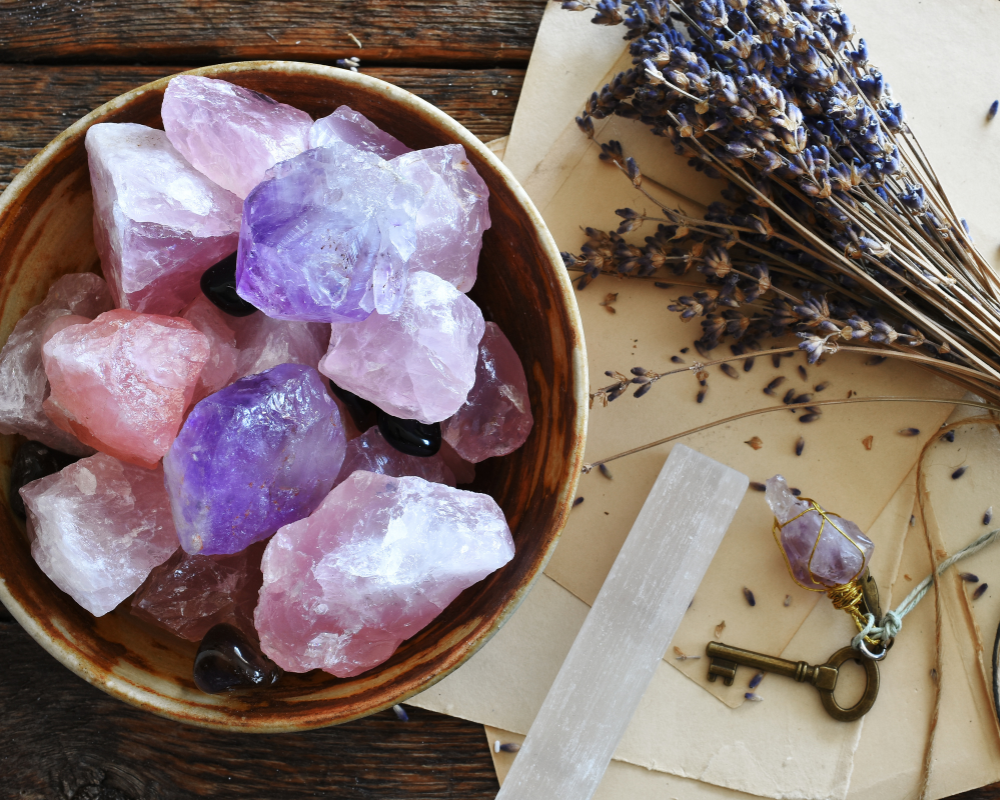 een kom met ruwe kristallen, een sleutel, pendel en gedroogde lavendel