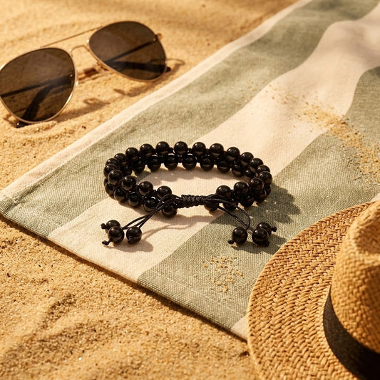 verstelbare zwarte agaat armband op een doek op het strand