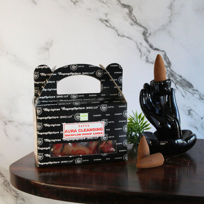 sfeerbeeld van een doosje backflow aura cleansing kegels met een marmeren achtergrond en een backflow brander met wat losse kegeltjes