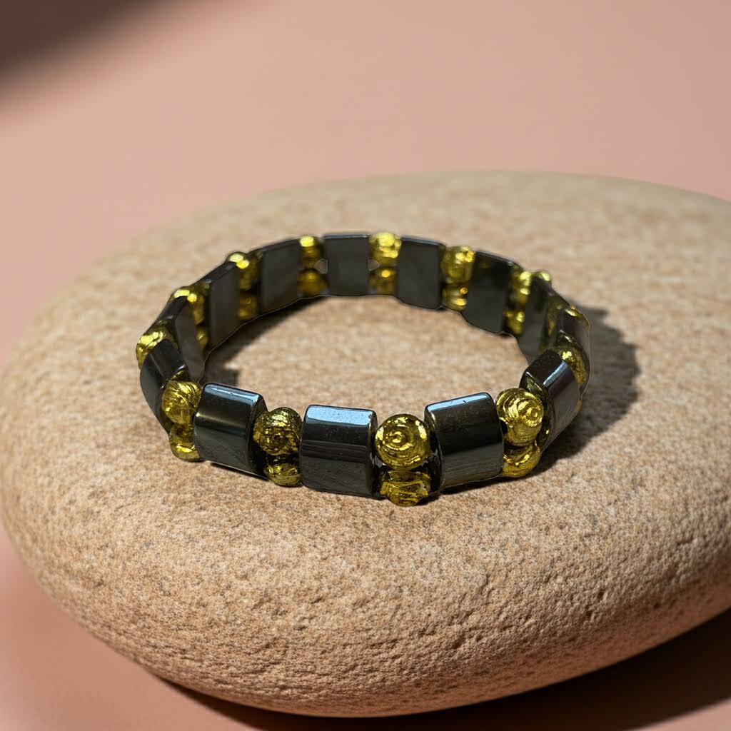 hematiet armband met goudkleurige roosjes op een kei