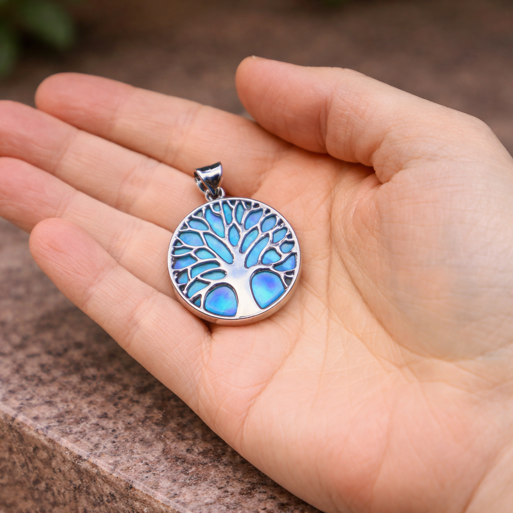 blauwe levensboomhanger met parelmoer in de hand