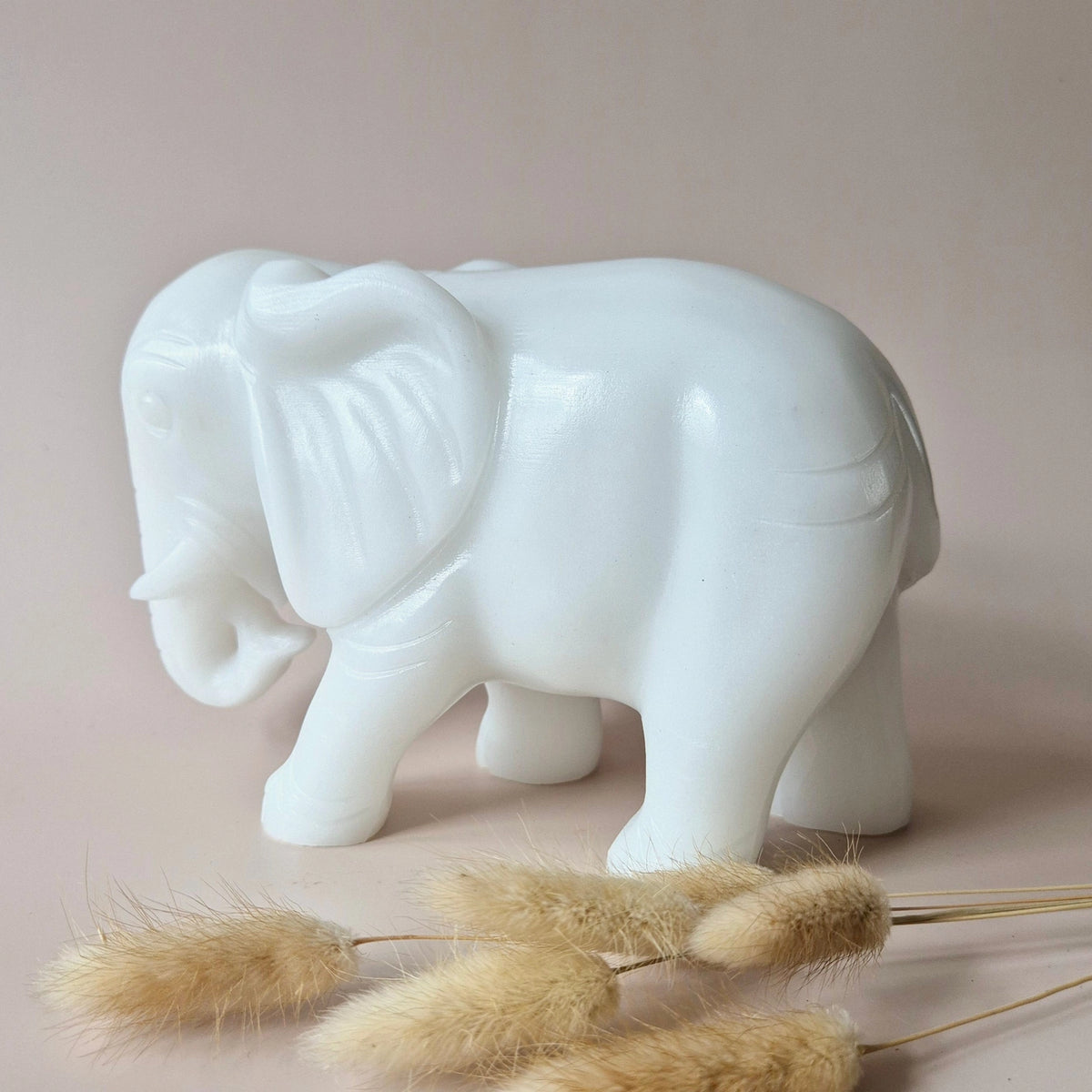 witte jade olifant met wat gedroogde bloemen