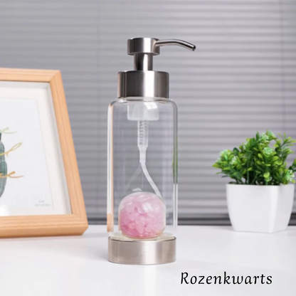 lege glazen kristalfles met rozenkwarts met plantje en kader op de achtergrond